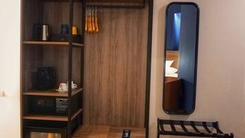 A wooden wardrobe with multiple shelves, a small table, and a mirror.