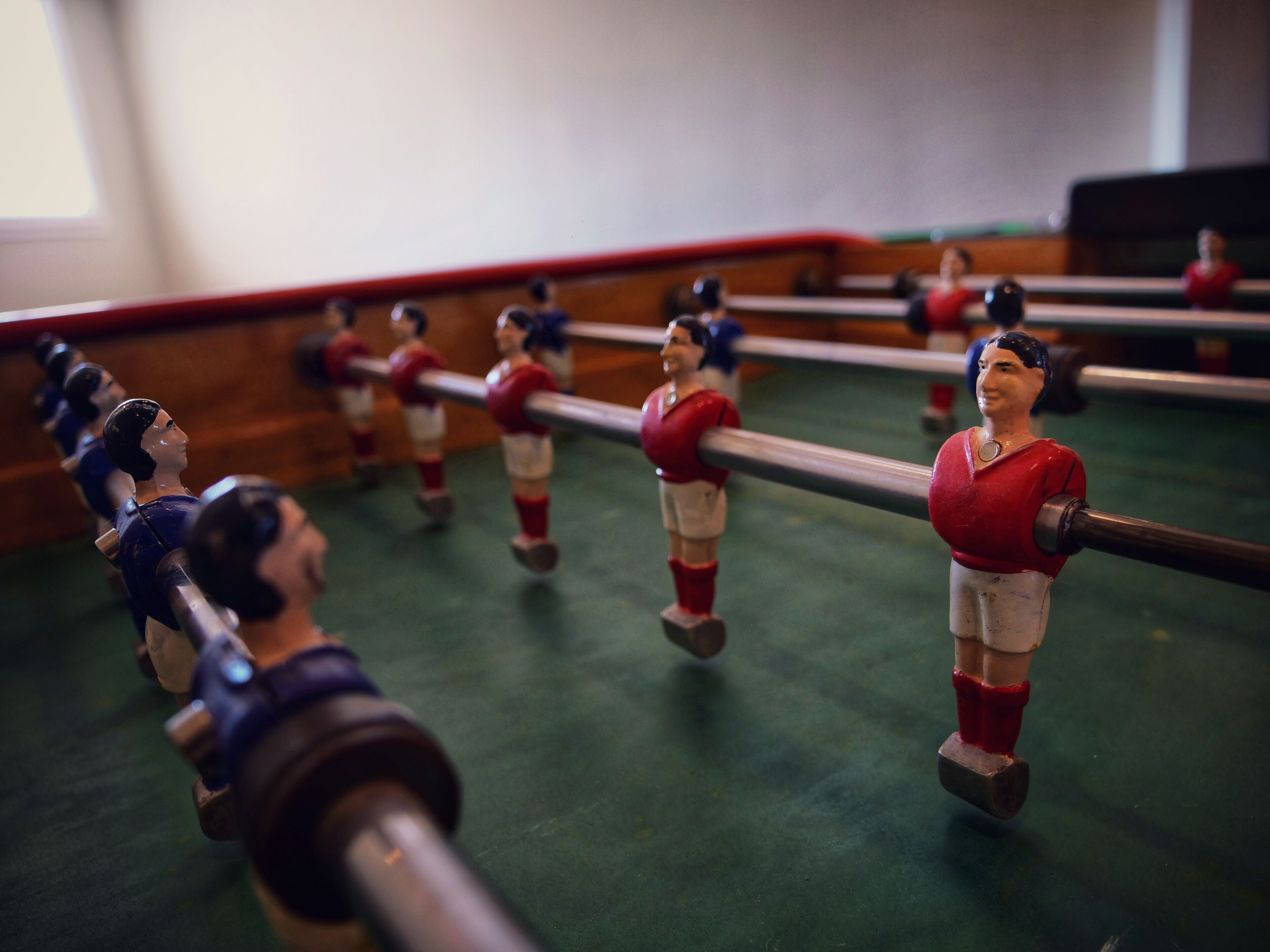 A foosball table with figures in red and blue uniforms.