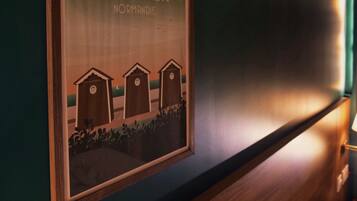 A framed sign with text and a simple illustration of three wooden structures, possibly birdhouses, on a wall.