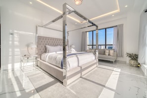 Une chambre moderne avec un lit à baldaquin, un canapé et une grande fenêtre donnant sur la ville.