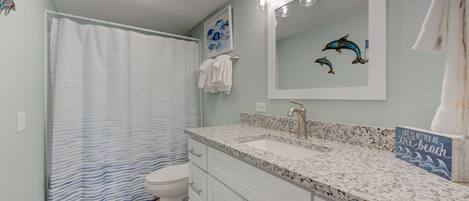 A bathroom with a shower, toilet, and sink.
