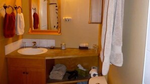 A bathroom with a wooden vanity, a sink, a mirror, and a towel rack. - Private studio appartment with great outdoor area (Canmore)