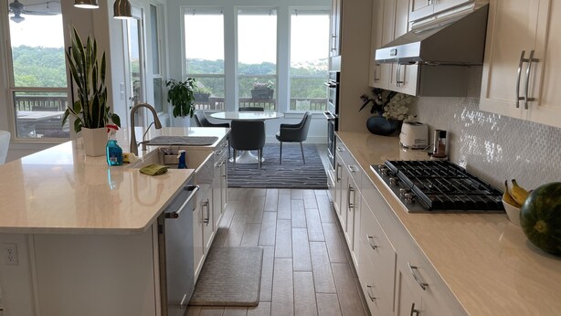 A modern kitchen with a large island, stainless steel appliances, and a view of the outdoors. - Modern Spacious Living (Austin)