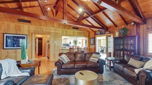 A spacious living room with leather sofas, a coffee table, and a large rug.