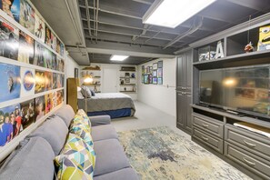 Relax in a stylish space with a large flat-screen TV, comfortable sofa, and a collection of framed pictures.