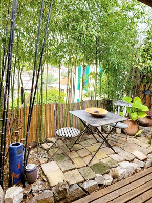 A bamboo garden with a table and chairs, surrounded by stone tiles and potted plants. - Charming villa with a hot tub, 10 minutes from the beach (Cannes)