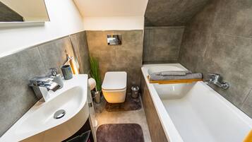 Een haardroger, handdoeken, zeep, toiletpapier