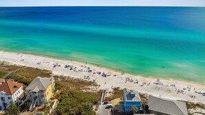 An aerial view of a beach with clear turquoise waters, sandy shore, and buildings in the foreground. - Coastal Lake View & Access! BIGGEST in Rosemary Beach PRIVATE Pool ! Sleeps 18 (Rosemary Beach)