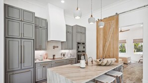 A modern kitchen with grey cabinets, a marble island, and pendant lighting. - Coastal Lake View & Access! BIGGEST in Rosemary Beach PRIVATE Pool ! Sleeps 18 (Rosemary Beach)