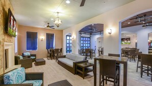 A spacious indoor area with wicker furniture, a sofa, and dining tables.