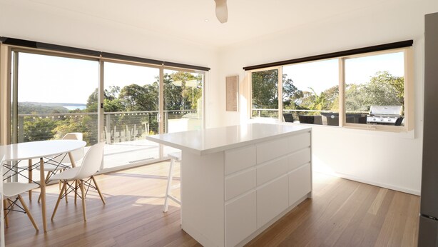 Una cocina moderna con una isla central, ventanas amplias y vistas al exterior.