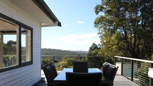 Una terraza con mesa y sillas, con vistas a un paisaje pintoresco.