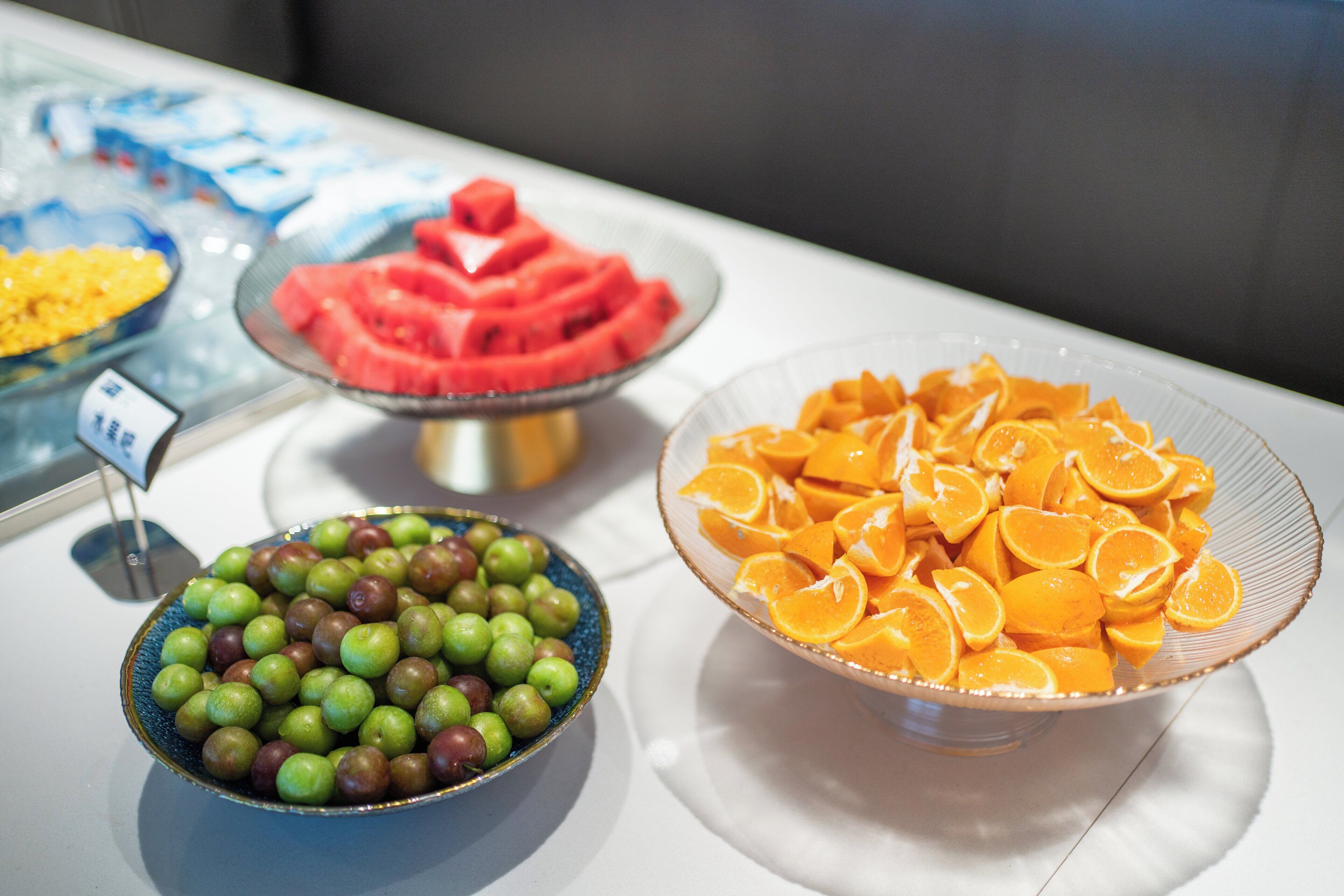 A buffet with various fruits including apples, oranges, and watermelon.