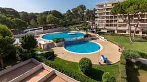 A resort with a large central pool, a smaller adjacent pool, and a building with balconies.