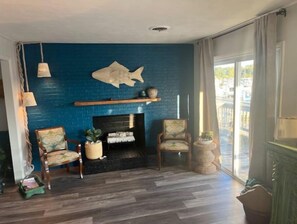 Relax in this inviting living room with a fireplace, armchairs, and a view of the outdoors.