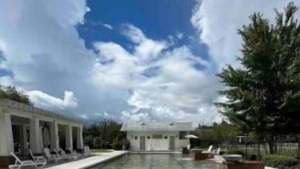 Una grande piscina all'aperto con lettini e un padiglione.