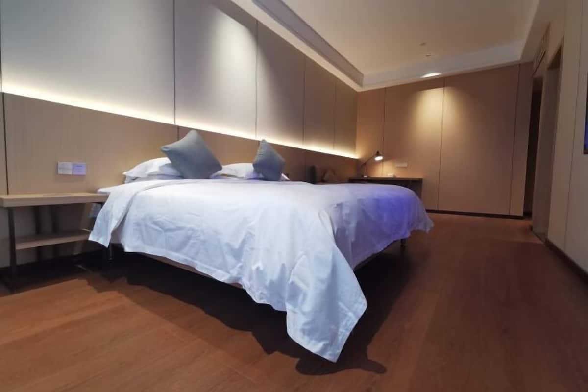 Ein modernes Schlafzimmer mit einem Bett, Nachttischen und einem Nachtschränkchen.