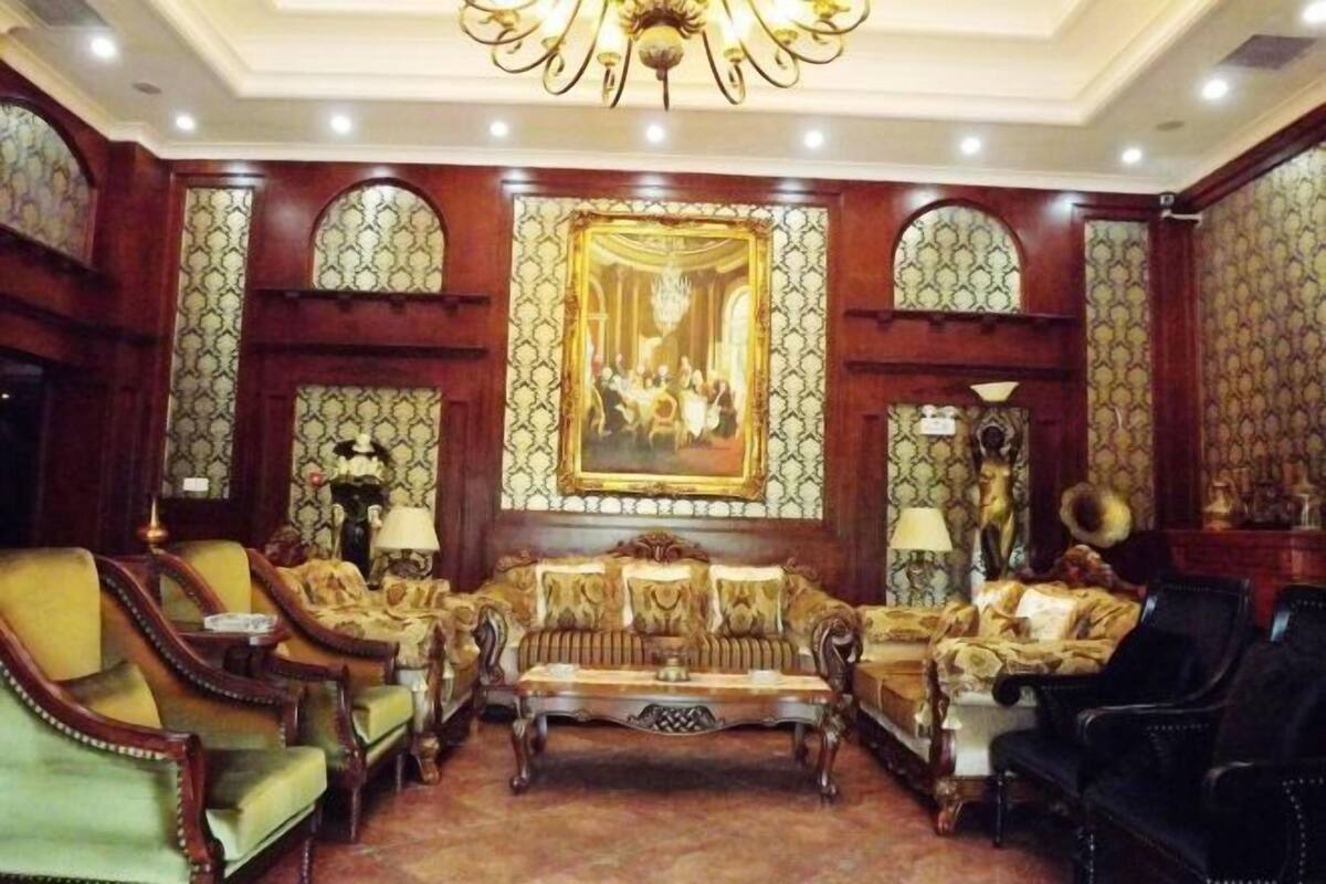 Una habitación lujosa con muebles decorados, una araña y papel tapiz estampado.