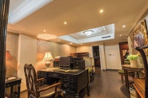 Una habitación de hotel con escritorio, silla, lámpara y luz en el techo.