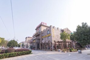 A hotel with a central courtyard, multiple floors, and a prominent entrance.