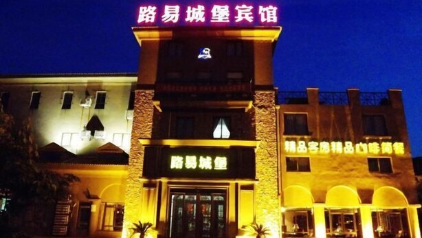 Un hôtel doté d’une entrée imposante et d’une enseigne en langue étrangère.