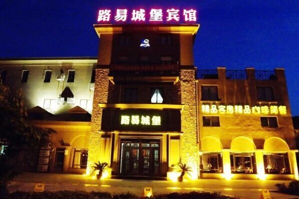 Un hotel con una entrada destacada y señalización en un idioma extranjero.