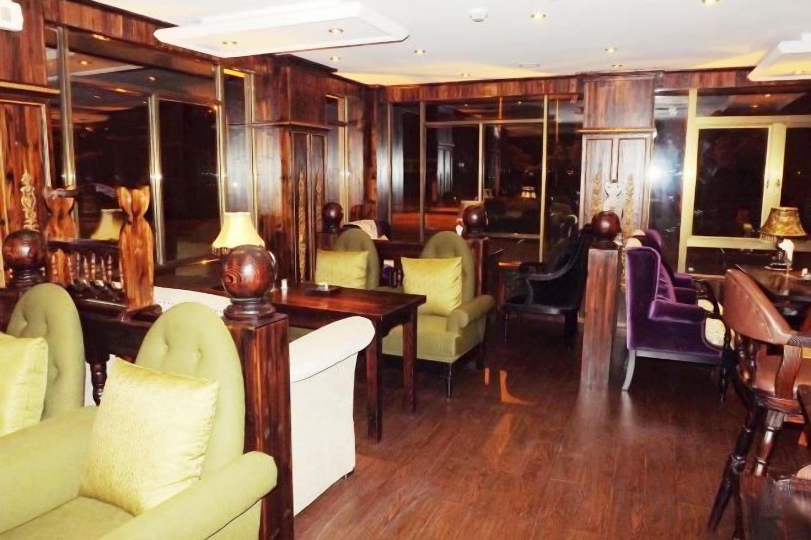 Un hall de hotel con zona de bar, disposición de asientos y vistas a través de las ventanas.