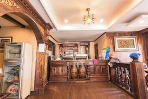 A hotel lobby with a wooden reception desk, a refrigerator, and a bar area. - Luyi Chengbao Hotel Tongling (Tongling)
