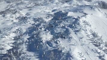 A snow-covered mountainous landscape with ski trails and cabins.