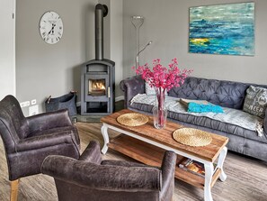 Smart-tv, eldstad, ett bordtennisbord och böcker
