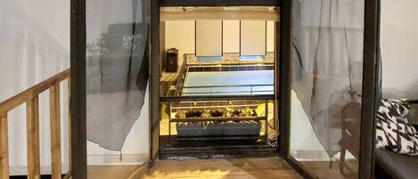 Une pièce comprenant un lit, un bureau et une chaise. Il y a une fenêtre avec des rideaux.