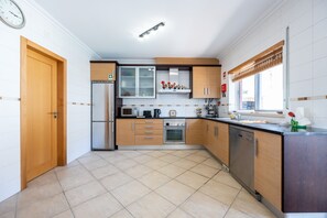 A modern kitchen with a refrigerator, microwave, oven, and dishwasher. - CoolHouses Algarve Burgau | Casa Boa Vida (Burgau)