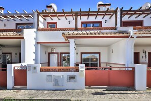 Un immeuble de deux étages doté d’un balcon, d’une porte et d’une boîte aux lettres.