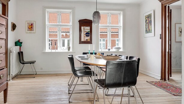 A dining area with a round table, black chairs, and a hanging light fixture. - Stunning home in Vestervig with WiFi (Vestervig)