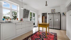 A modern kitchen with white cabinets, a large window, a built-in oven, and a two-door refrigerator. - Stunning home in Vestervig with WiFi (Vestervig)