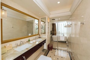 A modern bathroom with a large mirror, dual sinks, a bathtub, and a glass-enclosed shower area. - Mingdu Hotel (Zhenjiang)