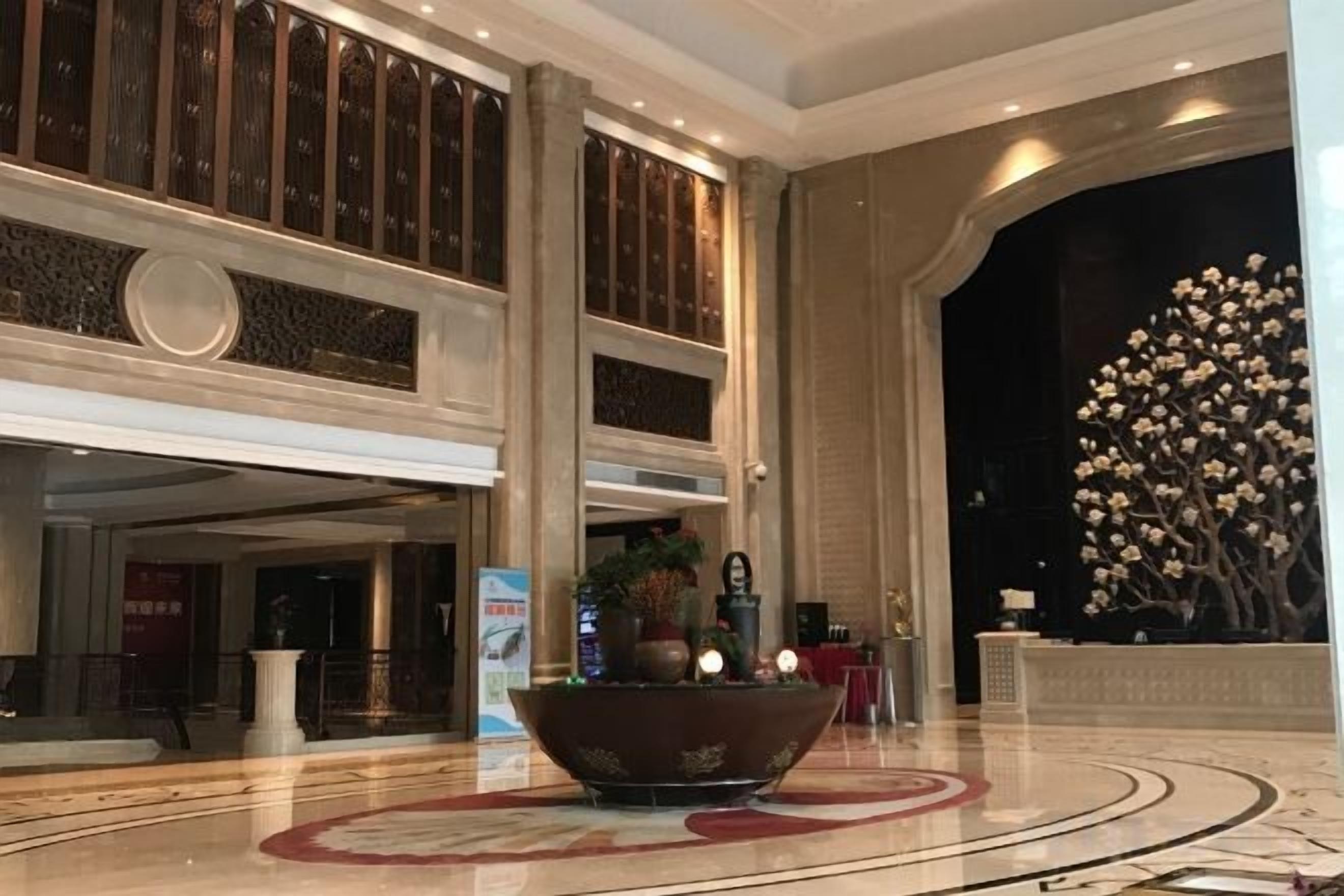 A lobby with a large decorative bowl, columns, and a large floral sculpture.