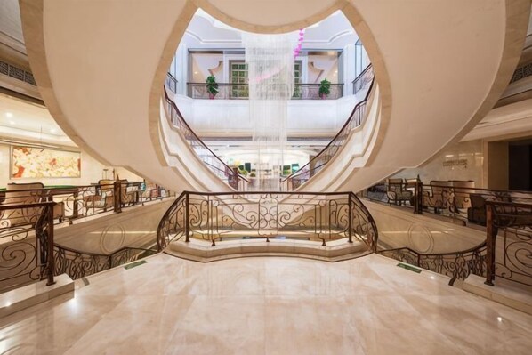 Un vaste atrium doté d’un élément aquatique central, de plusieurs étages et de balustrades décoratives.