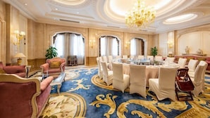 A luxurious hotel room with a large round table set for dining, elegant chairs, a chandelier, and ornate ceiling details. - Mingdu Hotel (Zhenjiang)