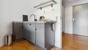 A compact kitchen with grey cabinets, a stainless steel trash bin, and a wooden countertop. - 2 bedroom awesome apartment in Fanø (Fanø)
