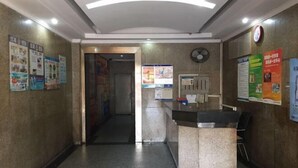 Zona de recepción con mostrador, carteles en las paredes y un reloj.