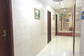 A hallway with doors, a bulletin board, and a tiled floor. - Xiangpeng Hotel (Shenzhen)
