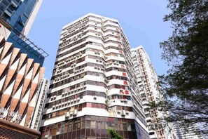 A high-rise building with multiple balconies, a modern architectural design, and a clear sky in the background. - Xiangpeng Hotel (Shenzhen)