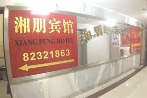 A hotel sign with the name 'Xiang Peng Hotel' and a directional arrow.