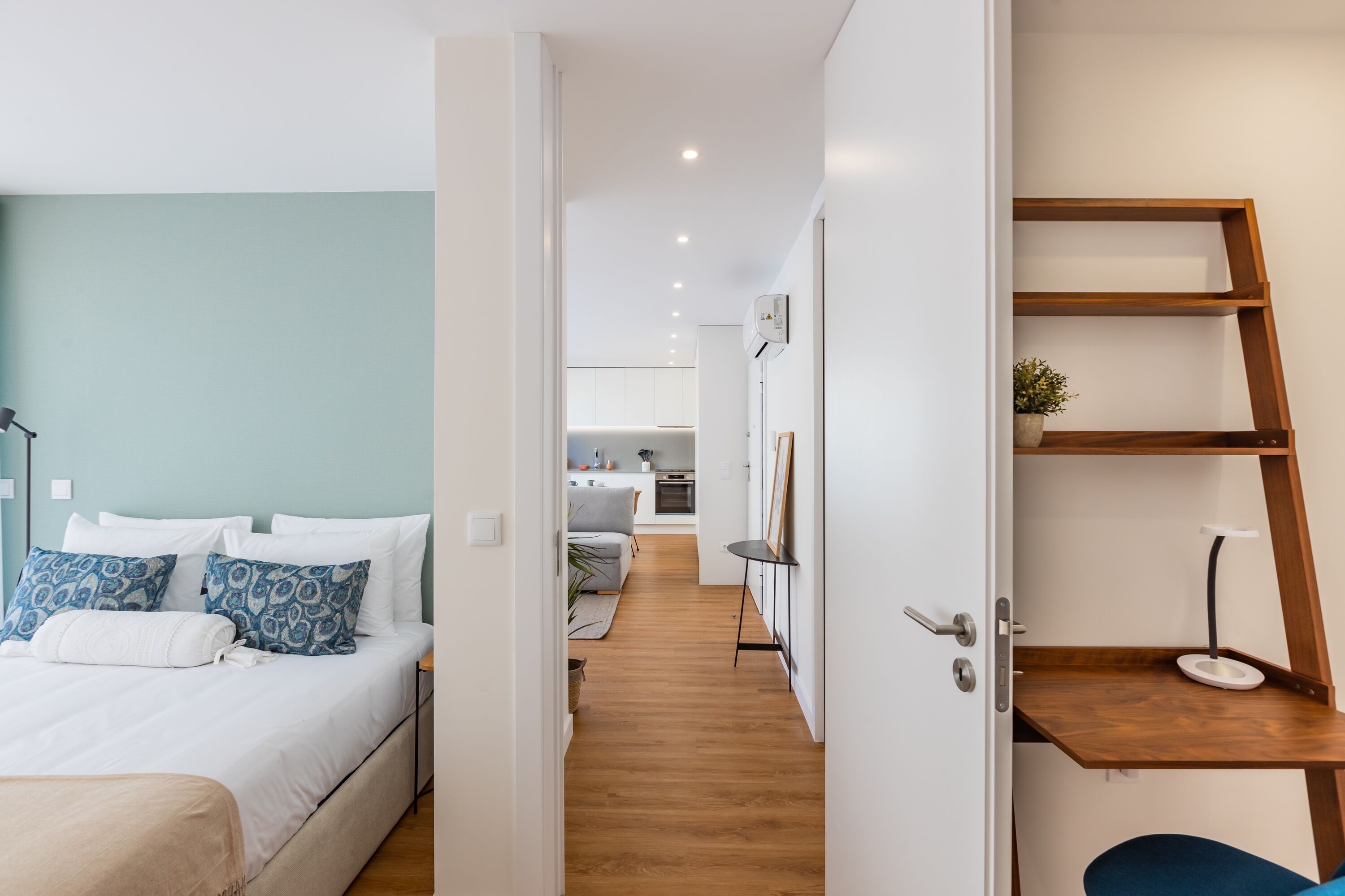 Une chambre d’hôtel moderne équipée d’un lit, d’une table de chevet et offrant une vue sur la cuisine.