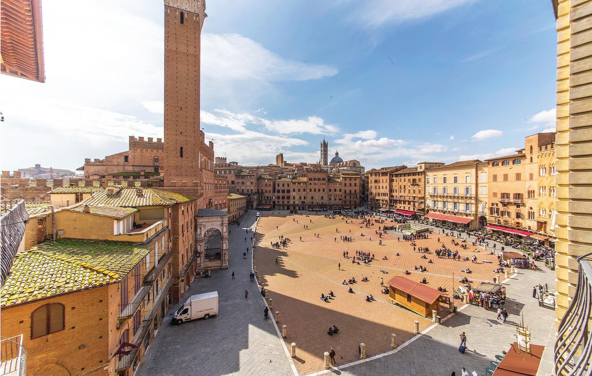 Una plaza amplia y abierta rodeada de edificios históricos, incluyendo una torre destacada.