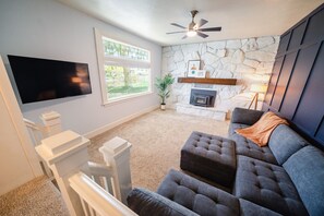 Una Smart TV, una chimenea, libros, una biblioteca de música