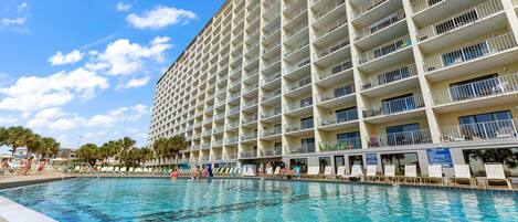 Un grand hôtel doté de nombreux balcons donnant sur une piscine.