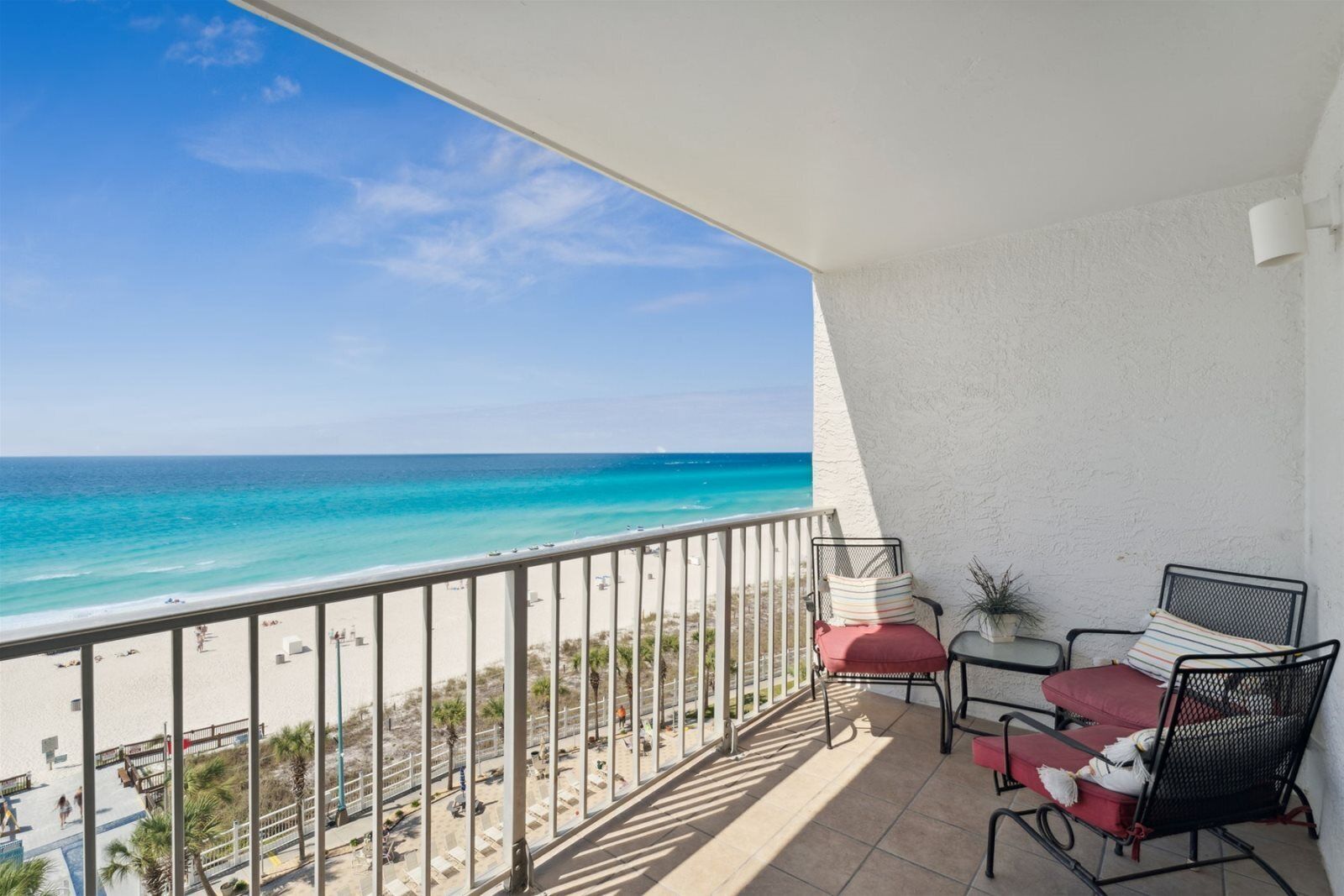 A balcony with a view of the beach and ocean.
