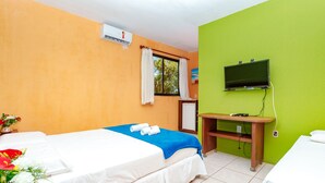 Una habitación de hotel con dos camas, un televisor y un escritorio.